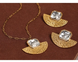 Detailed view of fan-shaped gold jewelry set with hammered texture and square crystal