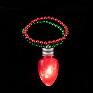 Macro shot of a glowing red LED bulb pendant with festive red and green beaded necklace