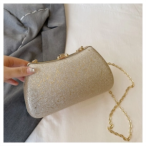Handheld view of a gold glitter evening clutch bag with chain strap and metal clasp