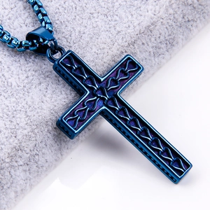 Close-up of blue stainless steel hollow cross pendant with heart pattern on silver chain