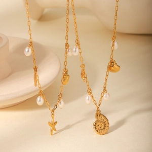 Detail of gold starfish and shell charms with pearls on a beach style necklace