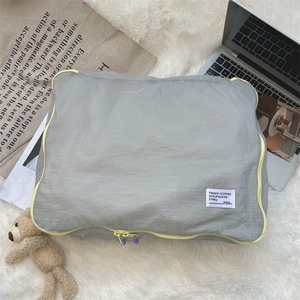 Detailed view of grey checkered travel organizer bag with contrasting yellow zipper