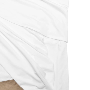 Detail view of white and light brown fabric texture showing off-shoulder pleated garment details