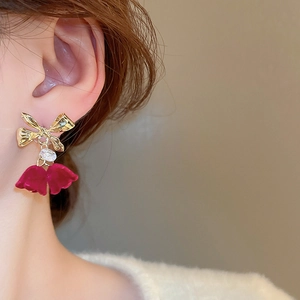 Close-up of elegant Christmas bow earrings with red velvet tassels and crystal stud