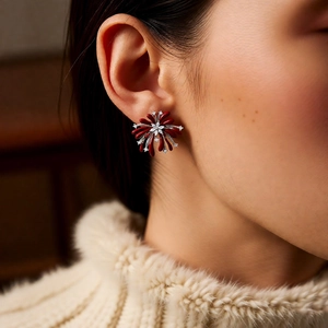 Close-up of vintage flower stud earrings with red petals and zircon stones on a model