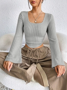 Detail of grey ribbed knit top featuring flared sleeves and a stylish U-neckline design