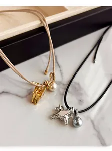 Détail de pendentifs cheval en perles et nacre incrustée sur des cordons en cuir fin