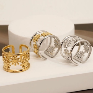 Adjustable hollow daisy rings in gold and silver finish on white minimalist pedestals