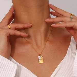 Macro view of 18K gold-plated tarot card necklace with sun and star relief patterns