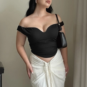 Haut moulant noir sexy à épaules dénudées et col en V assorti d'une jupe blanche