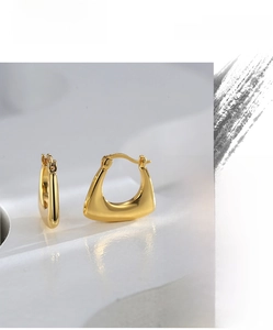 Macro detail of high quality minimalist gold irregular triangle geometric earrings