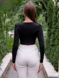Vue arrière du haut court noir à manches longues et du pantalon blanc à taille haute