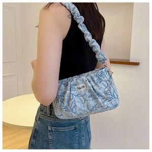 Detail of blue abstract print pleated shoulder bag with metallic chain and fabric strap