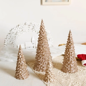Golden acrylic mini Christmas tree ornaments in four sizes on a lace tablecloth