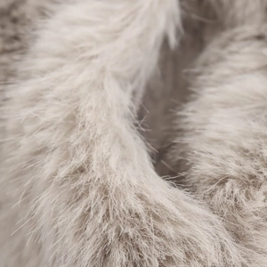 Close-up of soft faux fur texture on a warm winter jacket in light grey and beige tones