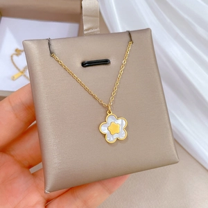Macro shot of gold star-shaped necklace with mother of pearl inlay on a jewelry display pad