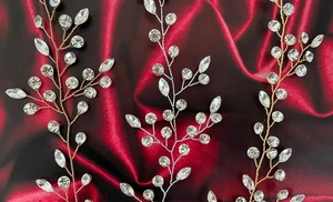 Detailed close-up of crystal bridal hair vines on dark red velvet background