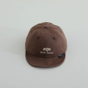 Détail de la broderie éléphant gris et du texte sur la casquette en coton marron pour enfant