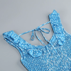 Detail of floral blue dress featuring smocked chest, ruffled straps and back tie design