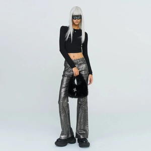 Mannequin style Y2K avec pantalon métallisé tenant un sac à main en fausse fourrure