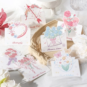 Flat lay of floral greeting cards with elegant illustrations and positive English phrases