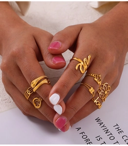 Close-up of gold geometric ring set featuring snake, crown and flower hollow designs