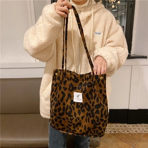 Detailed close-up of leopard print corduroy tote bag with decorative stitched label