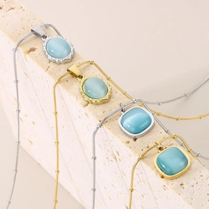 Close-up of vintage cat eye stone pendants on snake chains in gold and silver finish