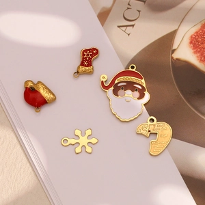 Macro detail of 18K gold plated Christmas charms including Santa, heart, and snowflakes