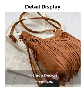 Detailed macro view of brown faux suede fringe shoulder bag with metal zipper closure