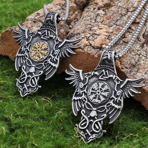 Macro detail of double crow Viking rune pendant on wood and moss background