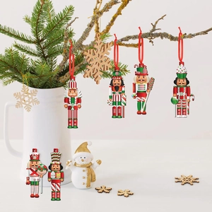 Detail of wooden Nutcracker soldier ornaments hanging from pine branches with red ribbons