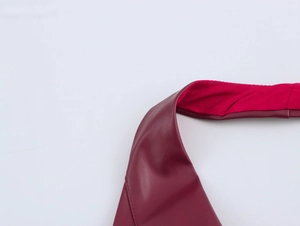 Nahaufnahme der weinroten PU-Ledertextur mit rotem Innenfutter und feinen Nähten am Kleid
