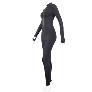 Close-up of black bodycon jumpsuit featuring front zipper and practical thumbhole cuffs