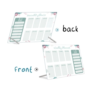 Macro view of clear acrylic weekly planner board with floral design and metal stand