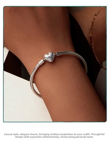 Macro shot of s925 sterling silver bangle with a sparkling diamond heart pendant