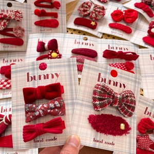 Red bow hair clip set for girls featuring velvet floral and plaid fabric textures
