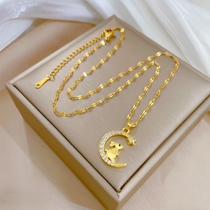 Elegant gold moon and rabbit necklace with sparkling crystals on white silk background