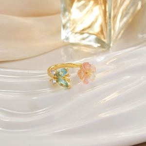 Detail of gold tulip ring featuring pink opal flower and blue zircon stones