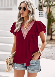 Close-up of red V-neck short sleeve shirt with delicate lace trim and ruffle details