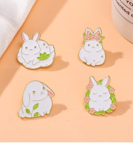 Detailed macro view of four cute white rabbit enamel brooches with floral accents