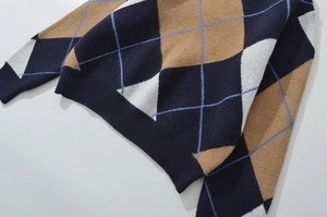Nahaufnahme des Rautenmusters und der Rippbündchen am Saum des Strickpullovers