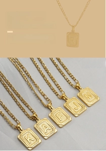 Détail de la chaîne Figaro en or 18 carats avec pendentif lettre rectangulaire homme