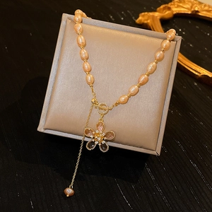 Detailed view of pink freshwater pearl necklace with T-bar clasp and crystal flower pendant