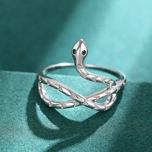 Macro shot of silver snake ring with green gem eyes and sparkling white crystals