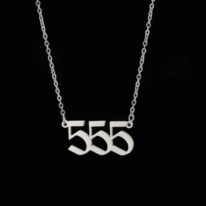 Vue macro d'un collier en acier inoxydable argenté avec pendentif chiffre ange 555