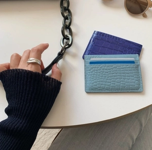 Detail showing high-quality croc-embossed card holders in light blue and deep purple