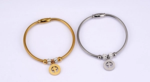 Detail of silver and gold snake chain bracelets featuring hollow cross charms and magnetic clasps
