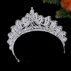 Detailed close-up of a silver bridal crown with crystal bow knots and sparkling rhinestones