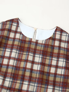 Detail of plaid dress keyhole back with round button and tartan textured fabric